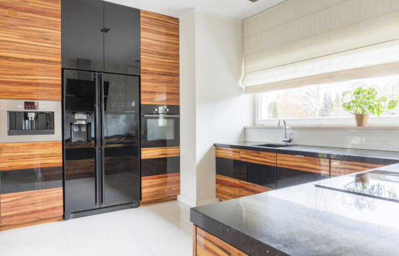 Kitchen with black marble worktop and fridge